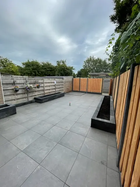 Tegelwerk met plantenbakk in een tuin, uitgevoerd door Klusbedrijf Gierveld in Hoofddorp